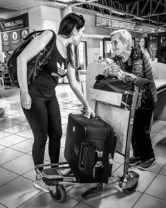 girl helping older woman with her luggage